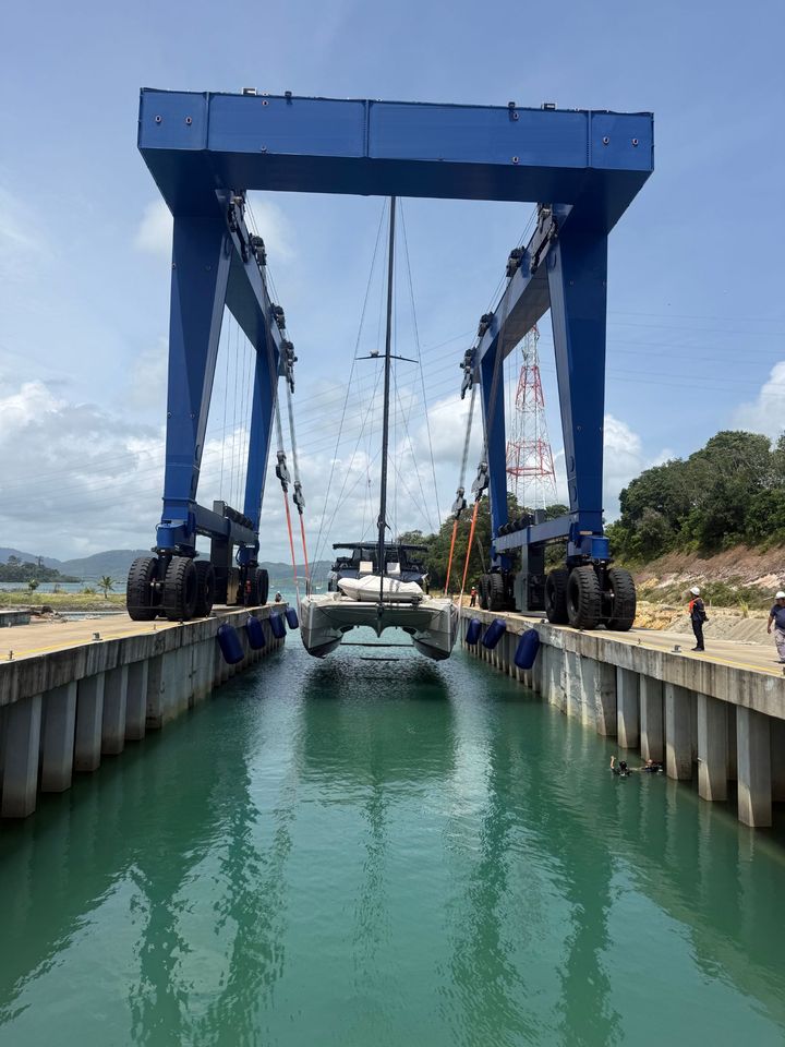 A catamaran being lifted by the travel lift at the shipyard