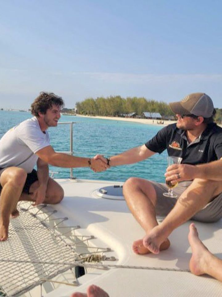 Two sailors shaking hands on the trampoline
